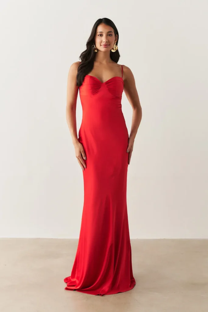 Modelo usando vestido longo de cetim vermelho com decote coração da Koji, ideal para convidada de festa de 15 anos