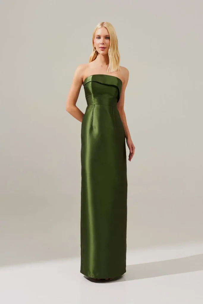 Modelo usando vestido longo verde oliva com saia lápis e corte assimétrico da Koji, ideal para convidada de festa de 15 anos moderna