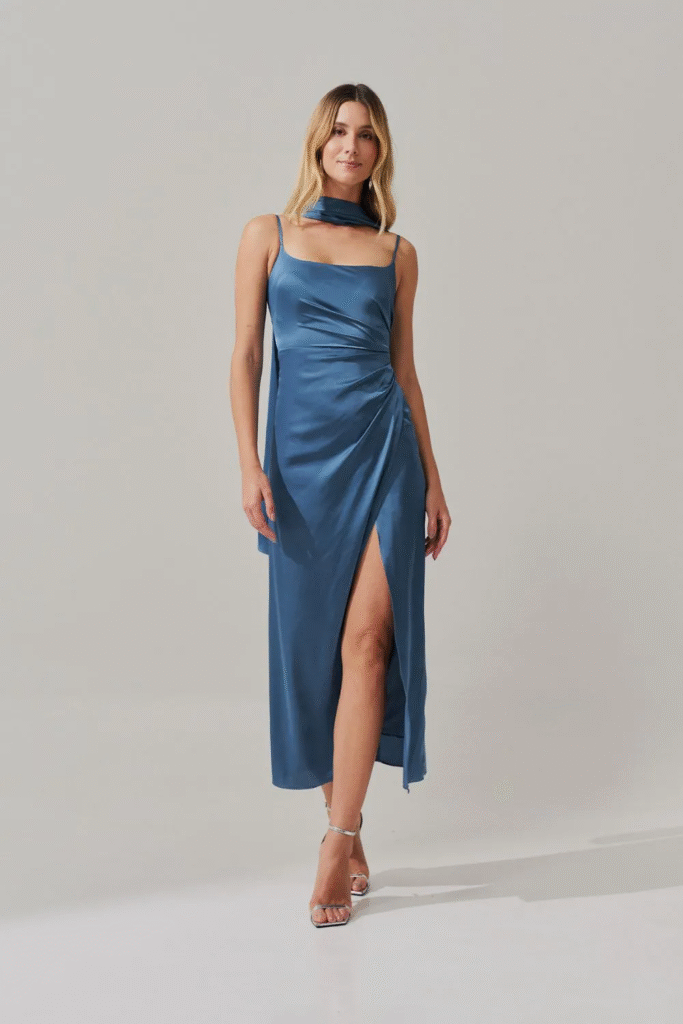 Modelo usando vestido long midi azul jeans com pregas e fenda lateral Dhaka da Koji, opção elegante para festas diurnas