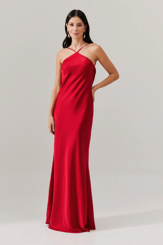 Modelo usando vestido midi fluido de cetim vermelho com amarração nas costas Capri da Koji, ideal para casamentos e formaturas