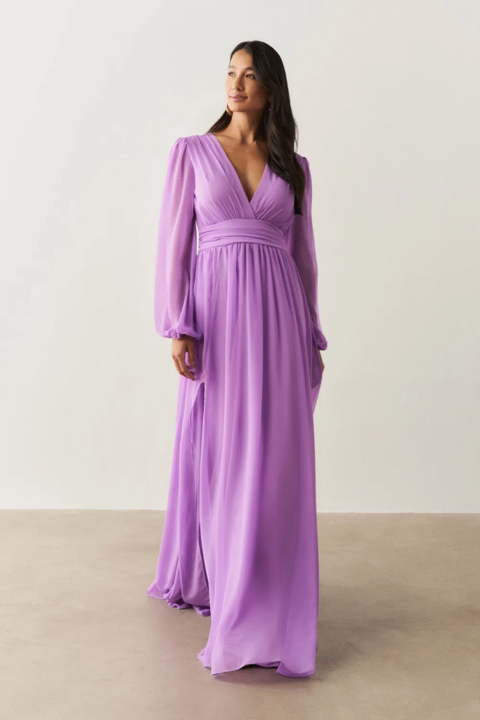 A modelo está usando o Vestido Longo com Decote V, Manga Longa e Fenda Lateral - Fabíola II Lilás